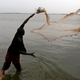 A man casts his fishing net into River Niger in southern Nigeria
